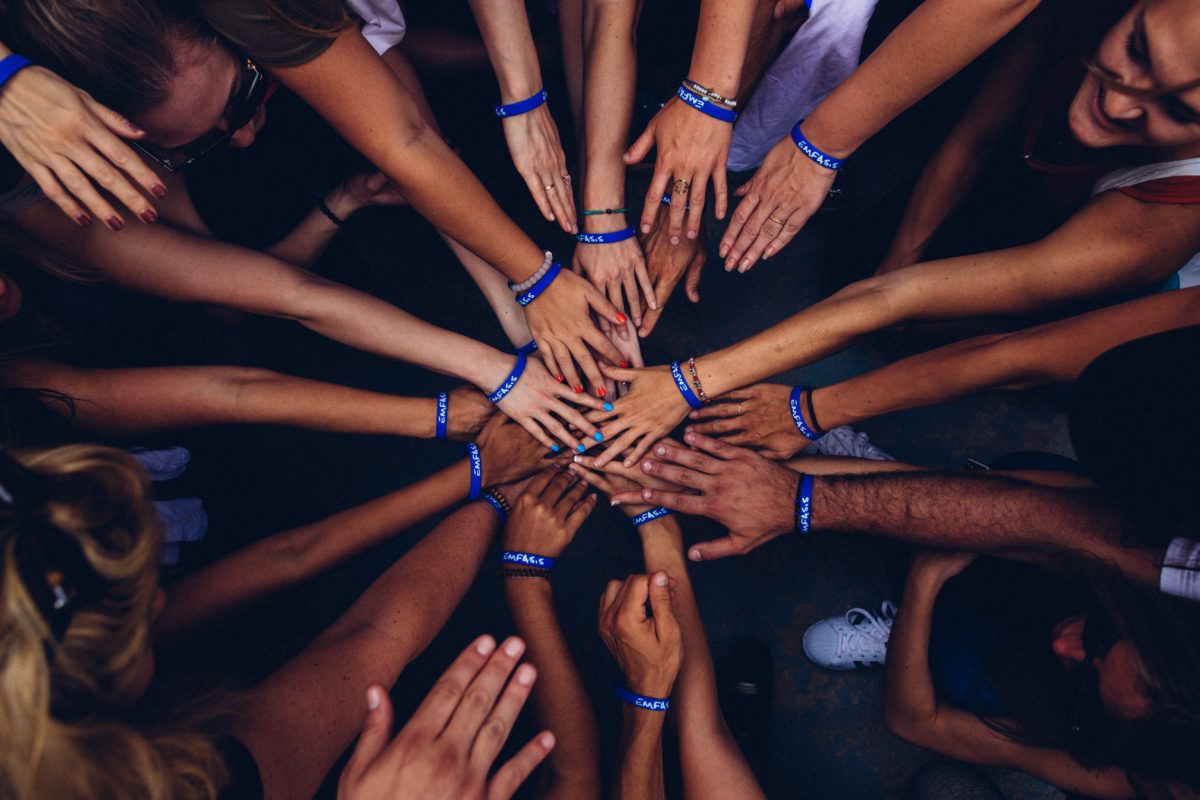 image of group of people putting their hands together in support